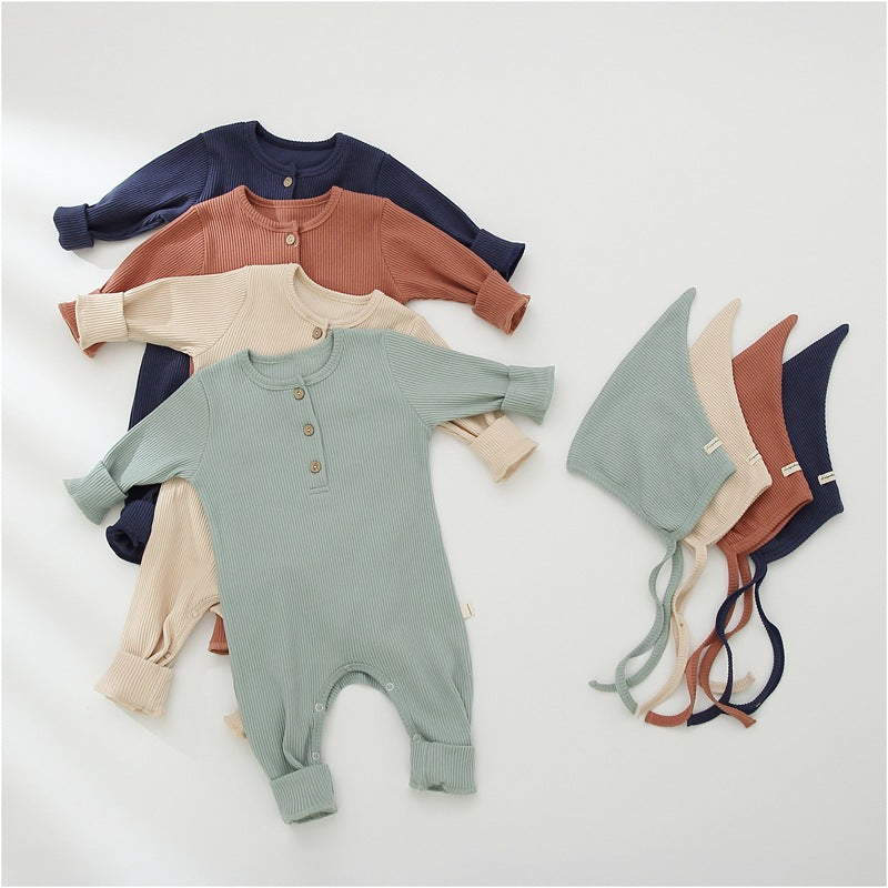 Set of baby rompers and hats in various colors on a light background