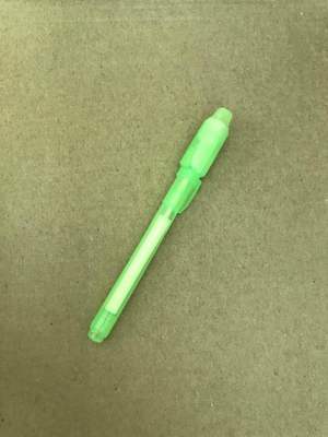 Green plastic object on a textured beige background