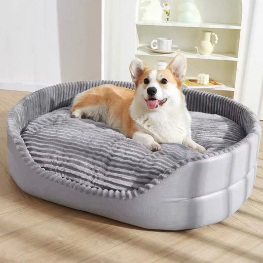 Dog lying on a gray pet bed in a room with a shelf in the background.