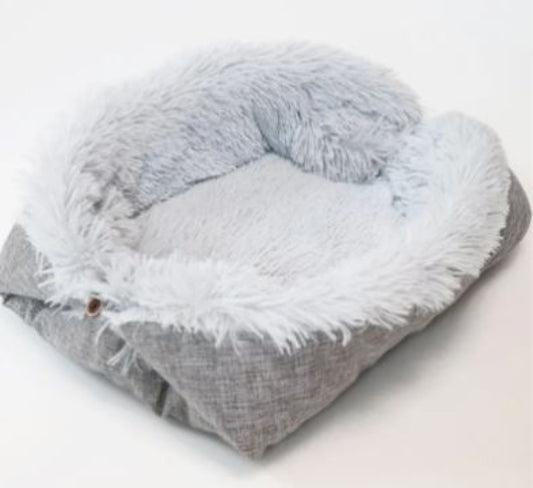Fluffy gray pet bed with white fur on a white background