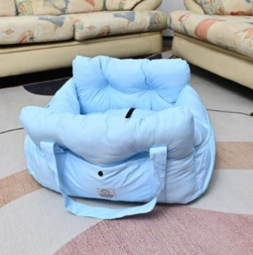 Blue baby seat on a checkered floor with a patterned sofa in the background