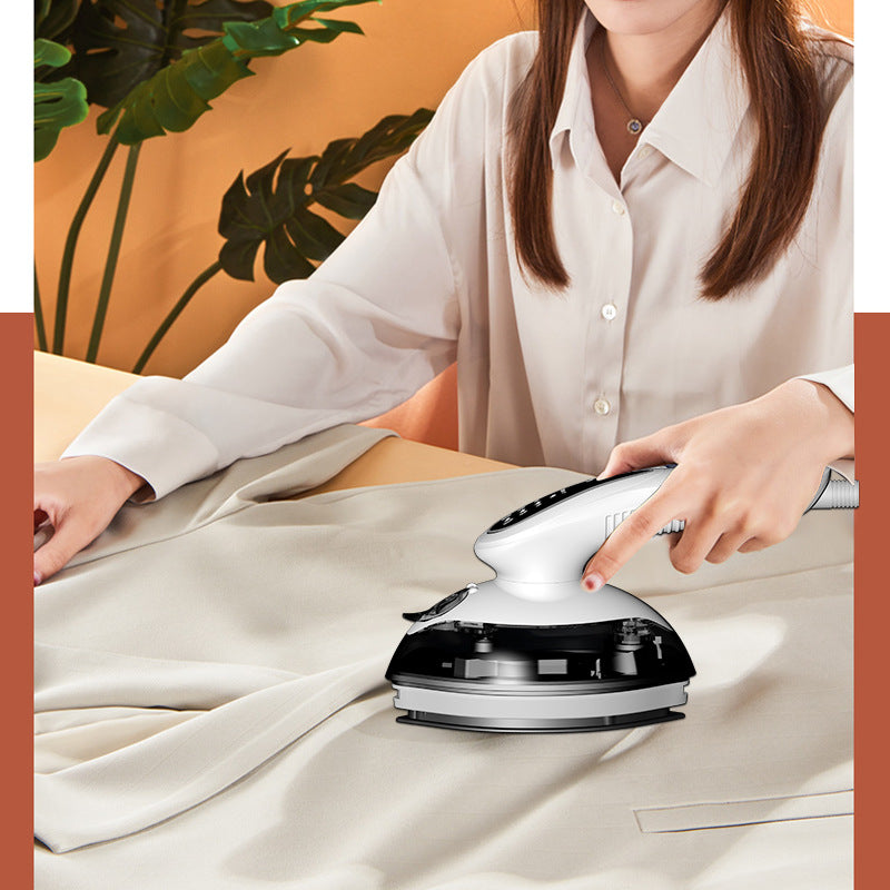 Person using a handheld steam iron on fabric with a plant in the background