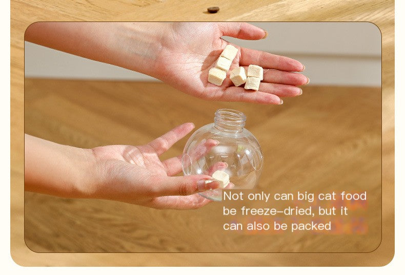 Hands holding freeze-dried cat food cubes above a clear bottle on a wooden surface.