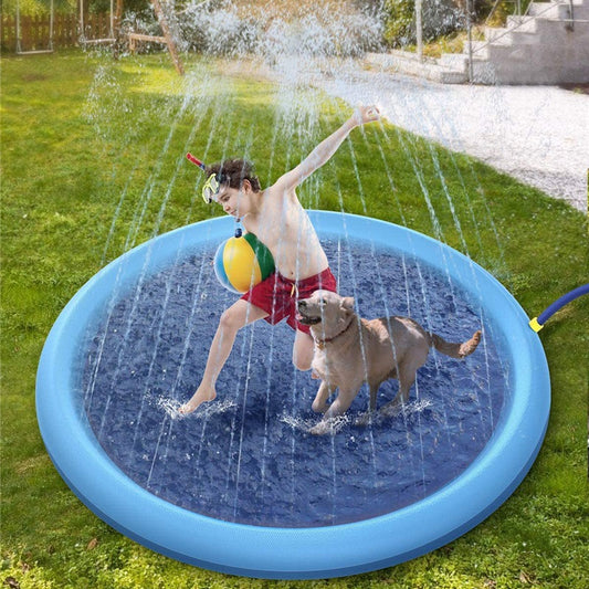Child playing with a dog in a blue inflatable sprinkler pad on grass