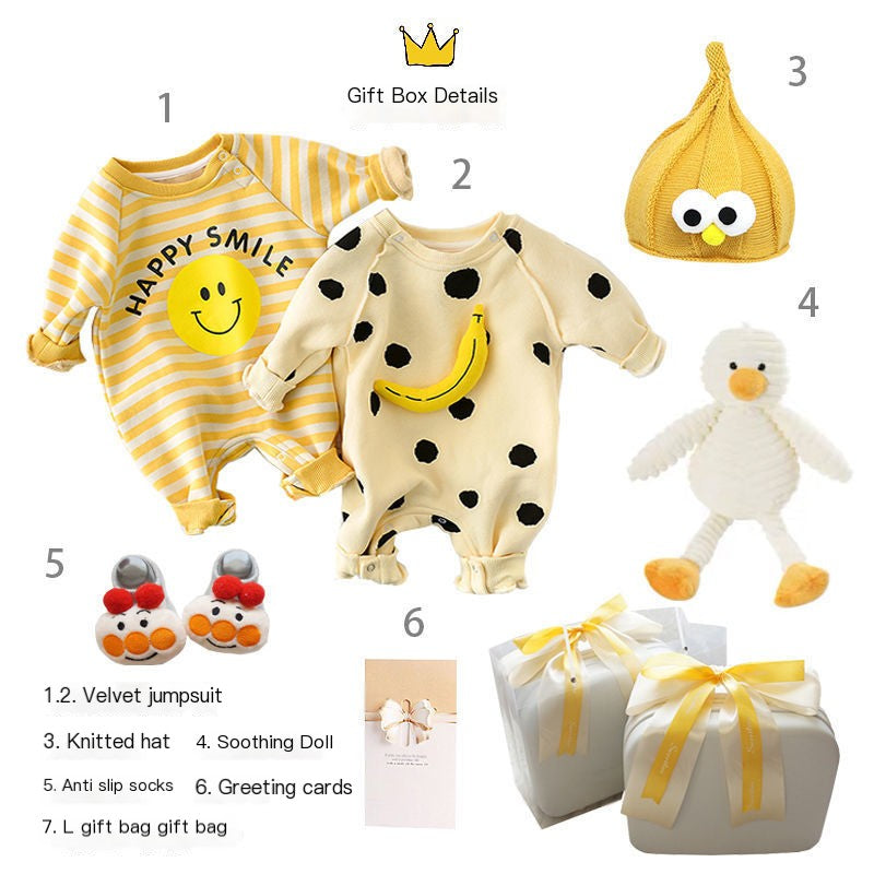Baby gift set with various items including a velvet jumpsuit, knitted hat, soothing doll, anti-slip socks, greeting cards, and a gift bag on a white background.