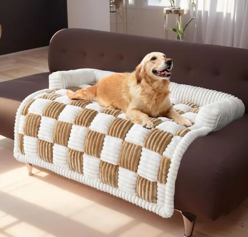 Dog lying on a checkered pet bed in a living room.