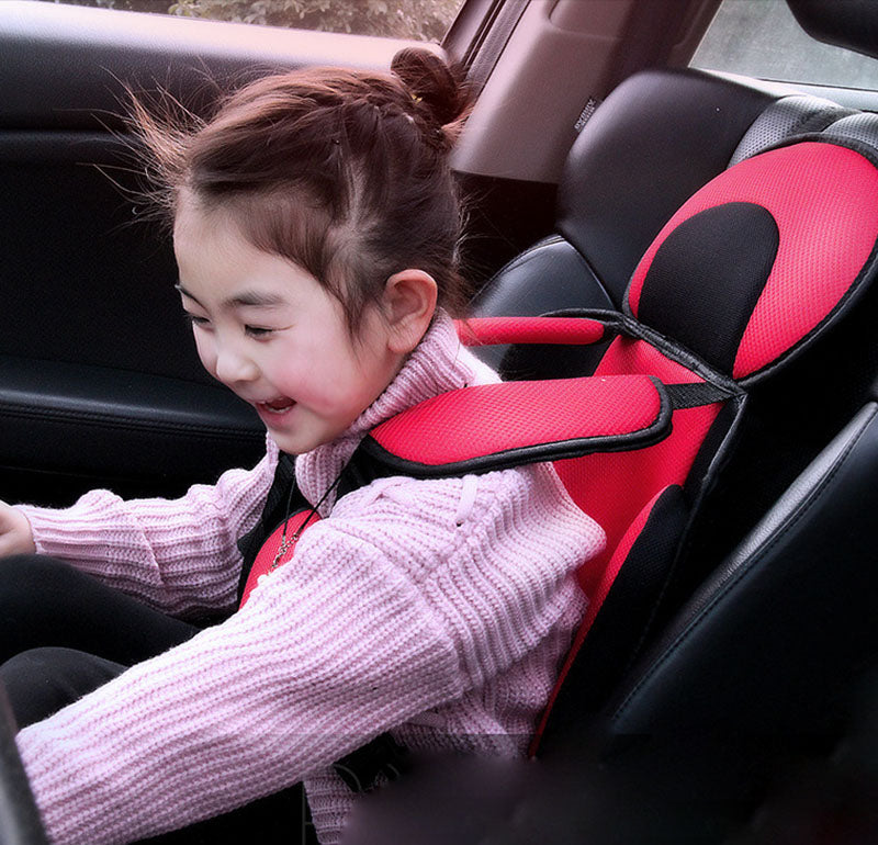 Child in a car seat with a red and black design
