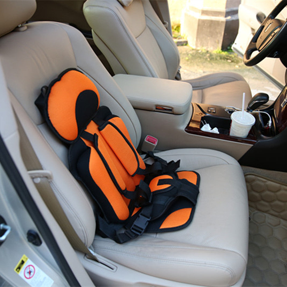 Orange and black child car seat in a car interior.