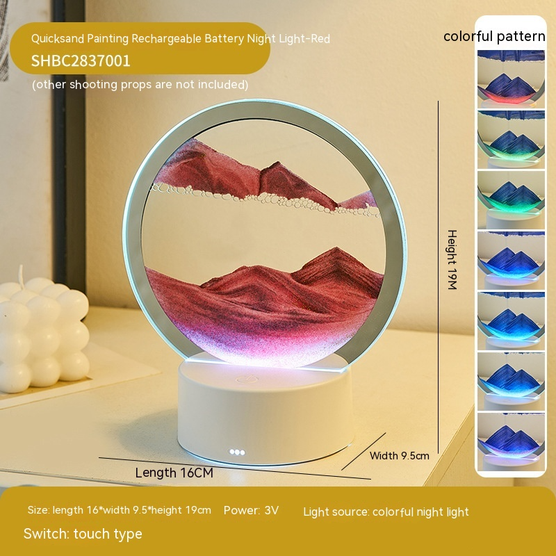 Round night light with mountain design and color-changing feature on a table.