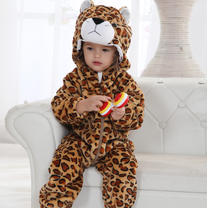 Child wearing a leopard print onesie with a hood, sitting on a white couch.