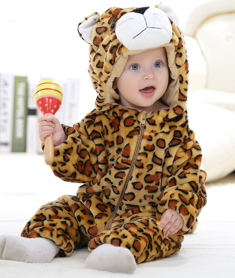 Baby in a leopard onesie holding a maraca on a white floor.