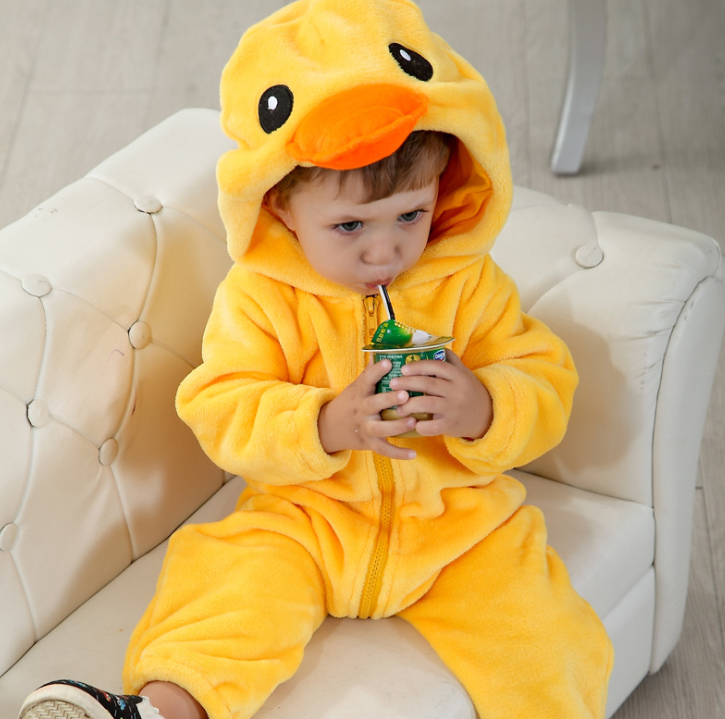 Child wearing a yellow duck onesie sitting on a white chair.