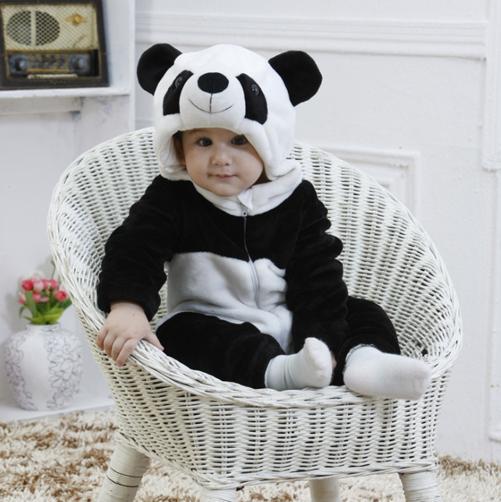 Baby in a panda costume sitting in a white wicker chair.