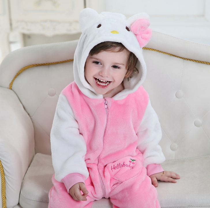 Child wearing a pink and white Hello Kitty onesie on a beige couch.